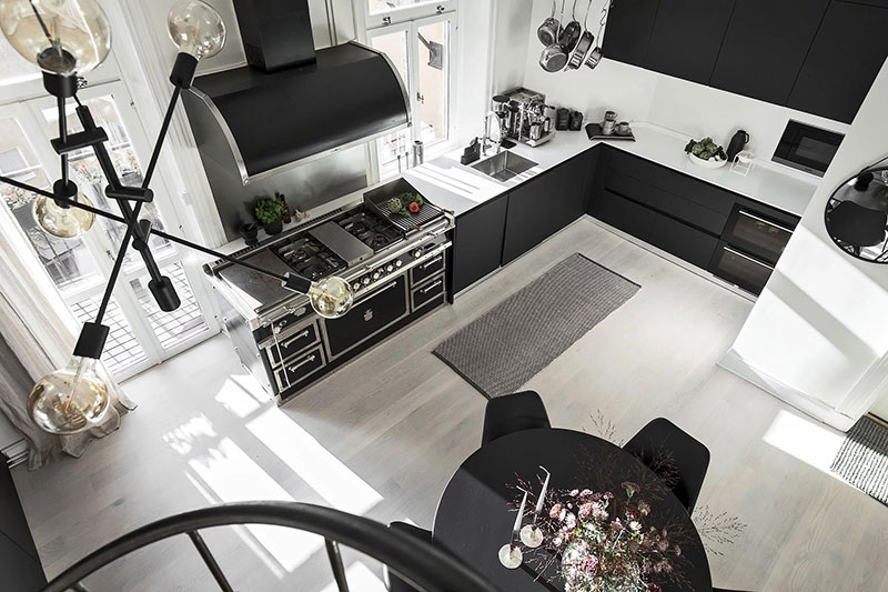 Двухуровневая квартира с черно-белой кухней и чердаком в Швеции