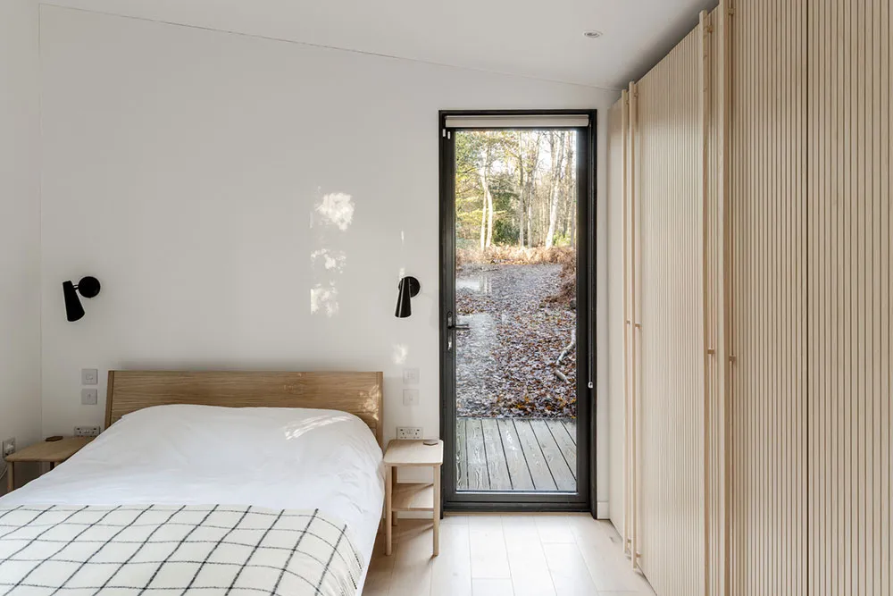 Czarny z zewnątrz i bardzo jasny w środku: nowoczesny domek w lesie w Anglii - Gallery image 11