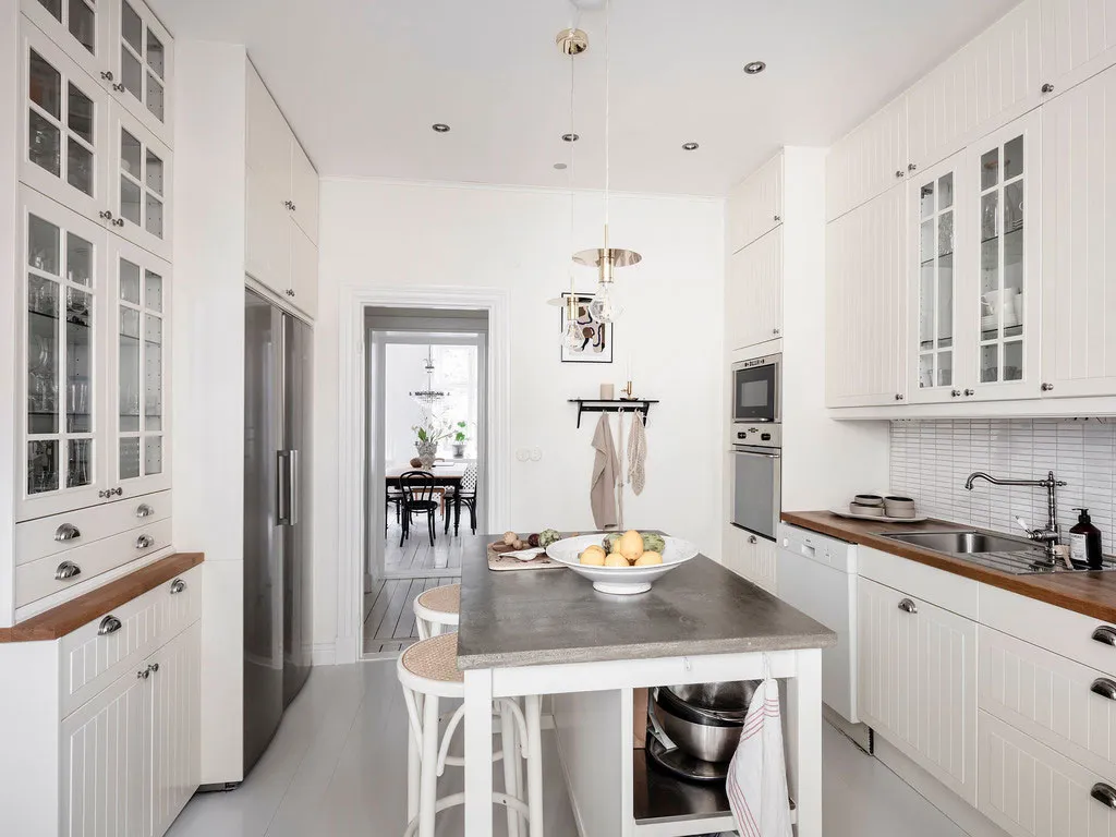 Білосніжний інтер'єр із кричною стіною на кухні в Швеції - Gallery image 17