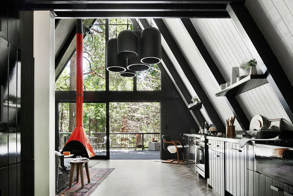 Accents noirs et cheminée rouge : une maison en forme de A dans la forêt - Gallery image 2