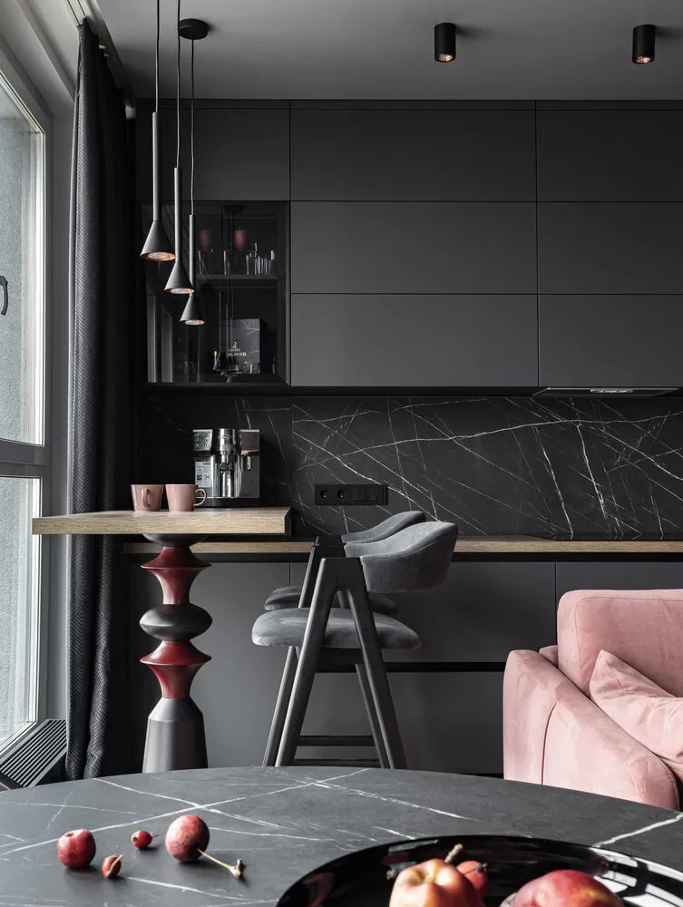 La barra de bar sirve como área de trabajo. Esta era la intención desde el principio. «Durante mucho tiempo no pudimos encontrar lámparas adecuadas para la barra de bar. Al final encontramos un modelo adecuado, pero tenía oro dentro, así que lo pinté con color cobrizo porque en la decoración de este espacio se usa cobre», comenta la diseñadora.