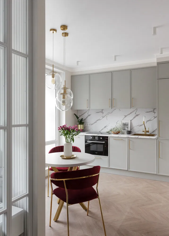 La mesa de comedor se fabricó a medida. Tiene una encimera neutra y una estructura de metal mate dorado. Las sillas están hechas en seda y añaden lujo al interior.