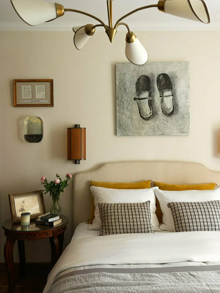 Ejemplo exitoso del diseñador Olga Komarova: si la pintura sobre la cabecera fuera más pequeña, las proporciones se verían alteradas. Pero aquí todos los elementos están bien elegidos (incluso los libros en la mesita no son demasiado grandes).