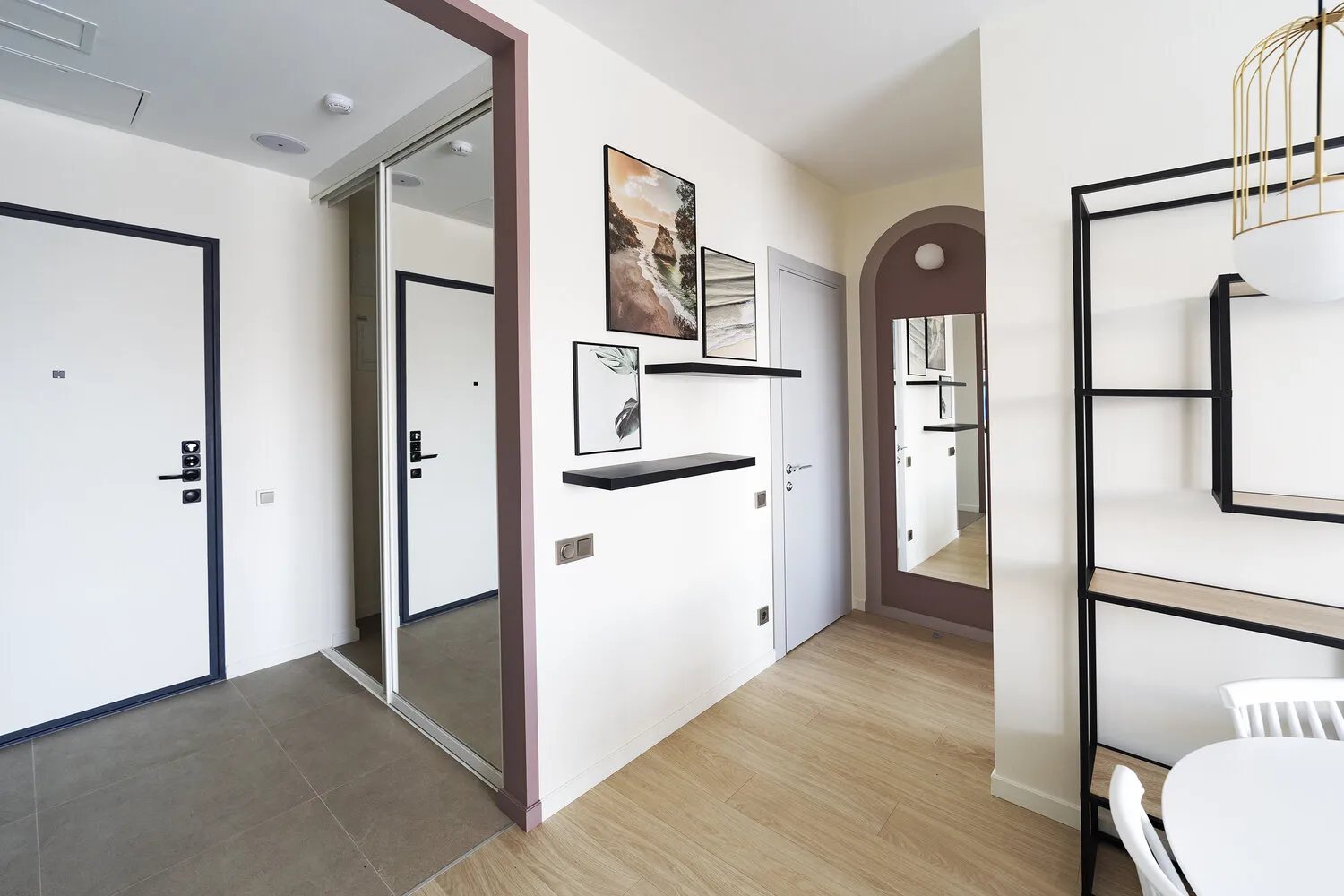 El almacenamiento de ropa de invierno y calzado se organiza en la entrada con puertas espejo correderas, dentro de las que hay una toma eléctrica que puede usarse, por ejemplo, para cargar una aspiradora inalámbrica.