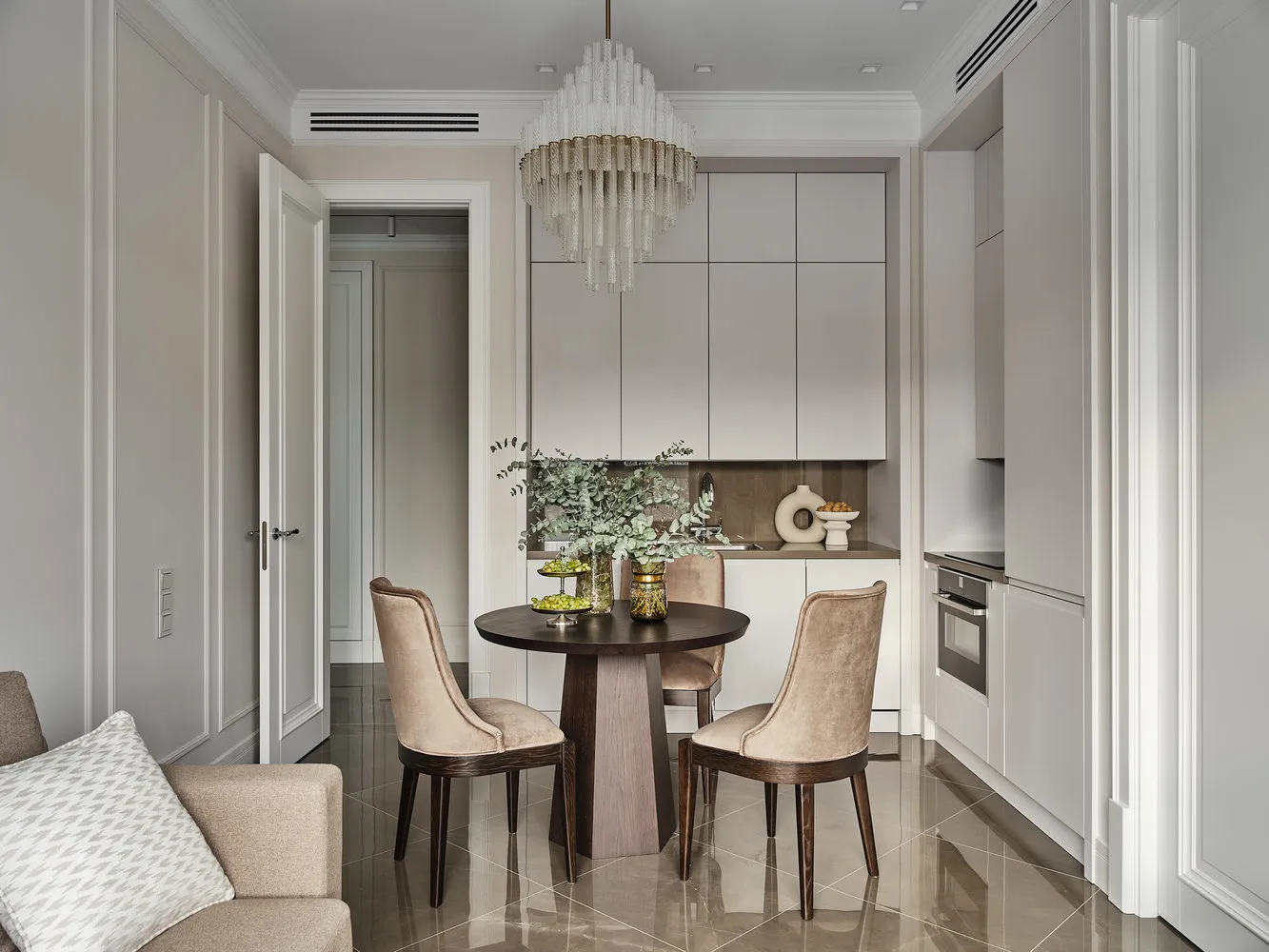 La zona de comedor se destacó con una mesa oscura y una lujosa lámpara que no puede pasar desapercibida.