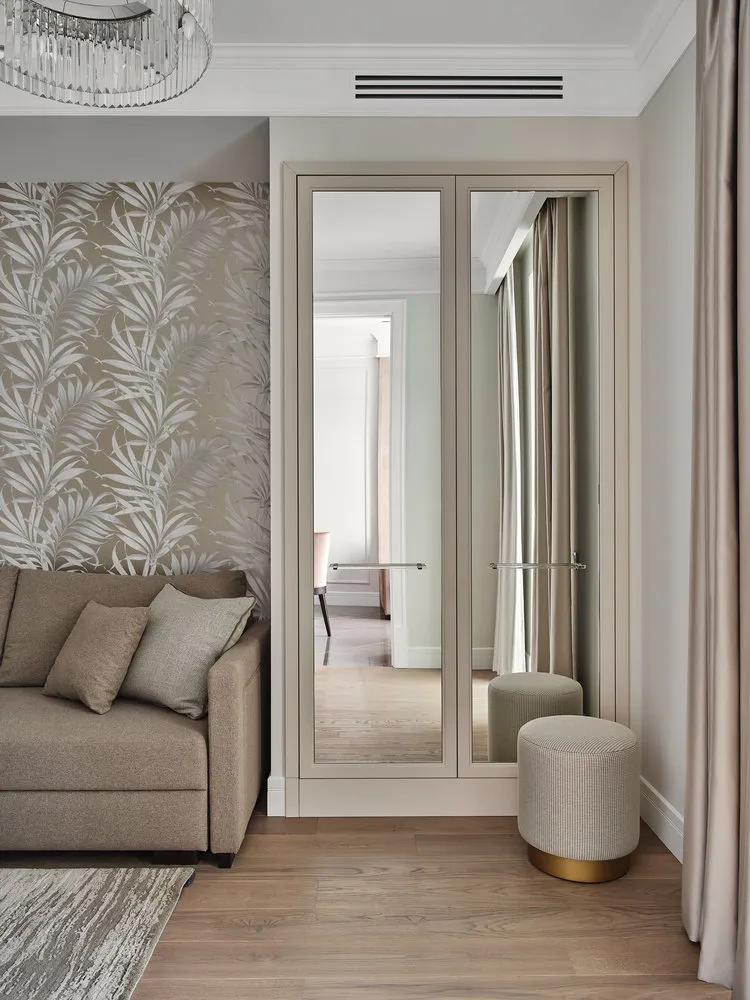 En las superficies de los armarios también se utilizaron espejos para ampliar el espacio. En la nicho hay papel pintado con motivos vegetales.