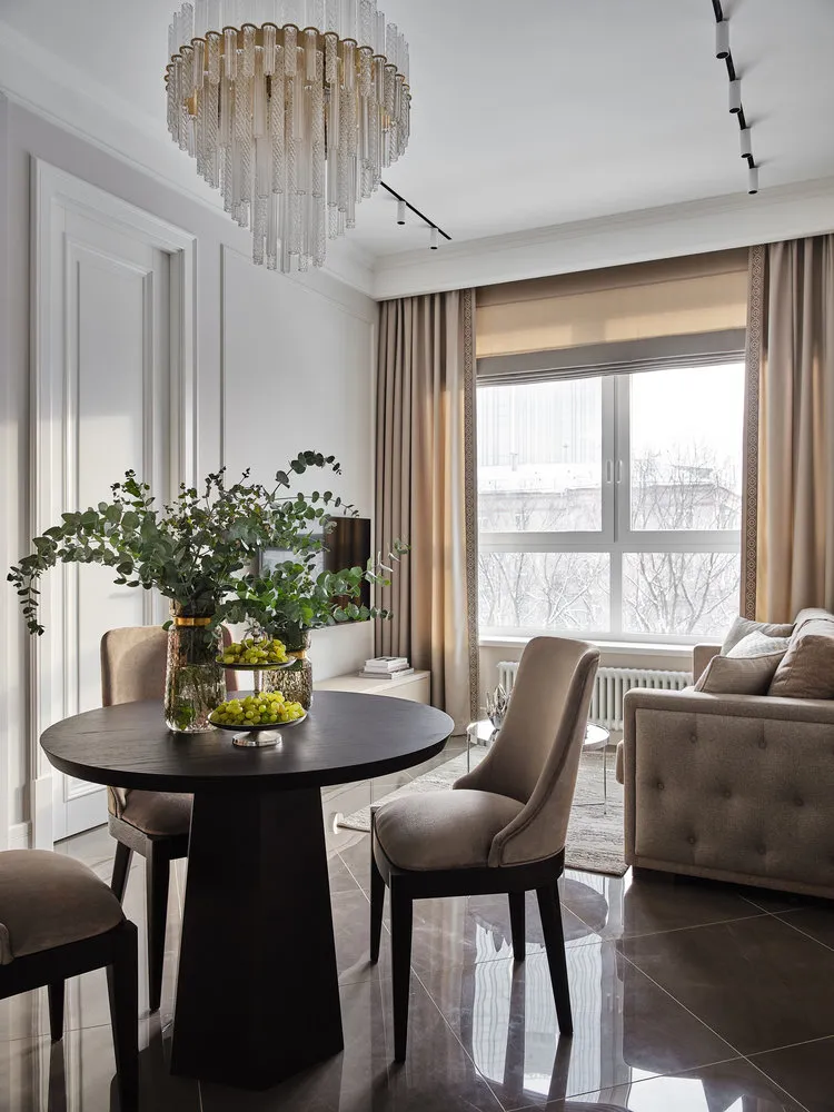 El revestimiento del suelo en la cocina-estancia es uniforme, es un ceramogranito brillante de tono gris-marrón que refleja la luz y añade volumen visual al espacio.