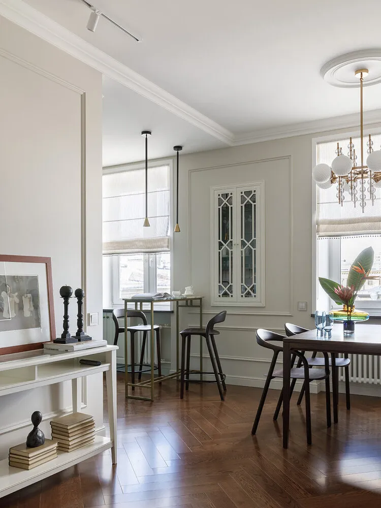 La barra de la zona comedor fue hecha según los bocetos del diseñador con piedra natural. Se fabricó especialmente una base metálica para ella. La barra tiene como objetivo separar visualmente el espacio de preparación de alimentos y el comedor. Las lámparas sobre la barra también separan visualmente estas áreas.