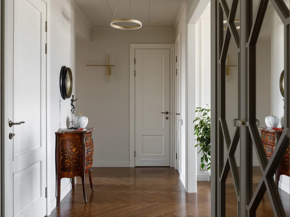 La abertura en la sala comedor fue ampliada no solo para permitir más luz al pasillo sino también para mostrar la cómoda Boulle tan querida por los dueños. La cómoda del fin del siglo XIX, heredada por la dueña de la casa desde su bisabuela y el único objeto que sobrevivió al asedio, guardado cuidadosamente por la familia.