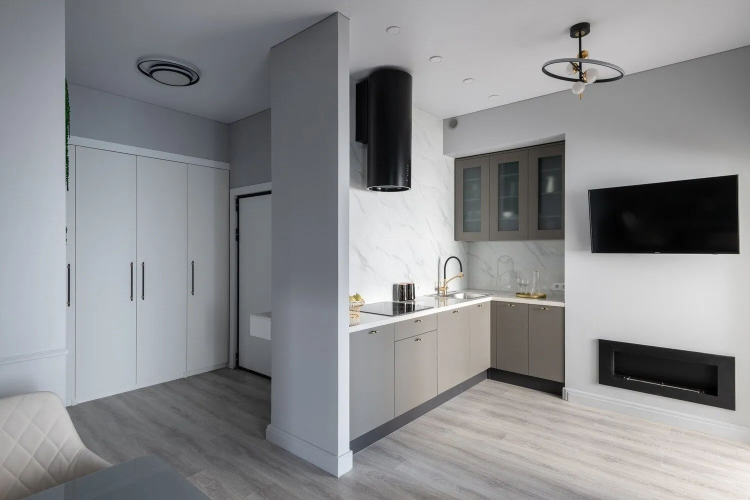 La chimenea aporta calidez al espacio y visualmente resalta el televisor negro en la pared clara.