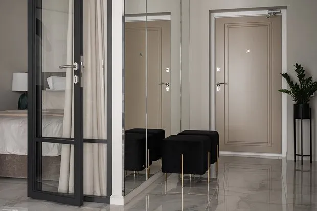 Una pared en la entrada se decoró con espejo para ampliar visualmente el espacio.