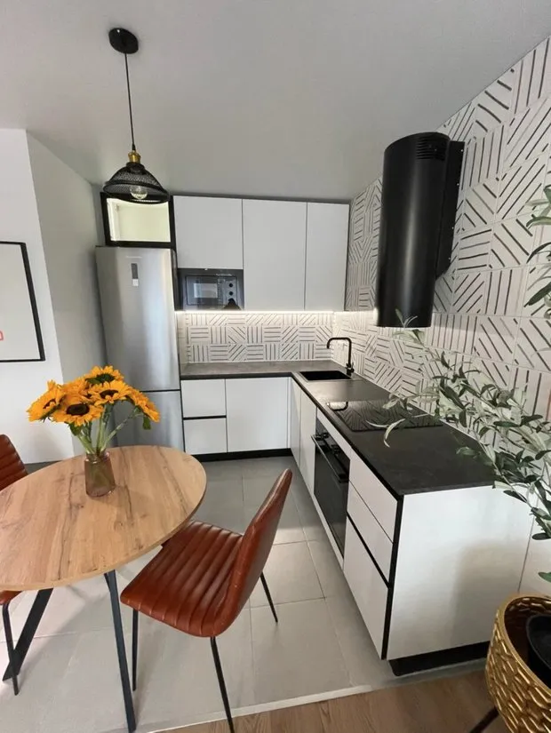 Iluminación a lo largo del mueble de la cocina y encima del refrigerador.