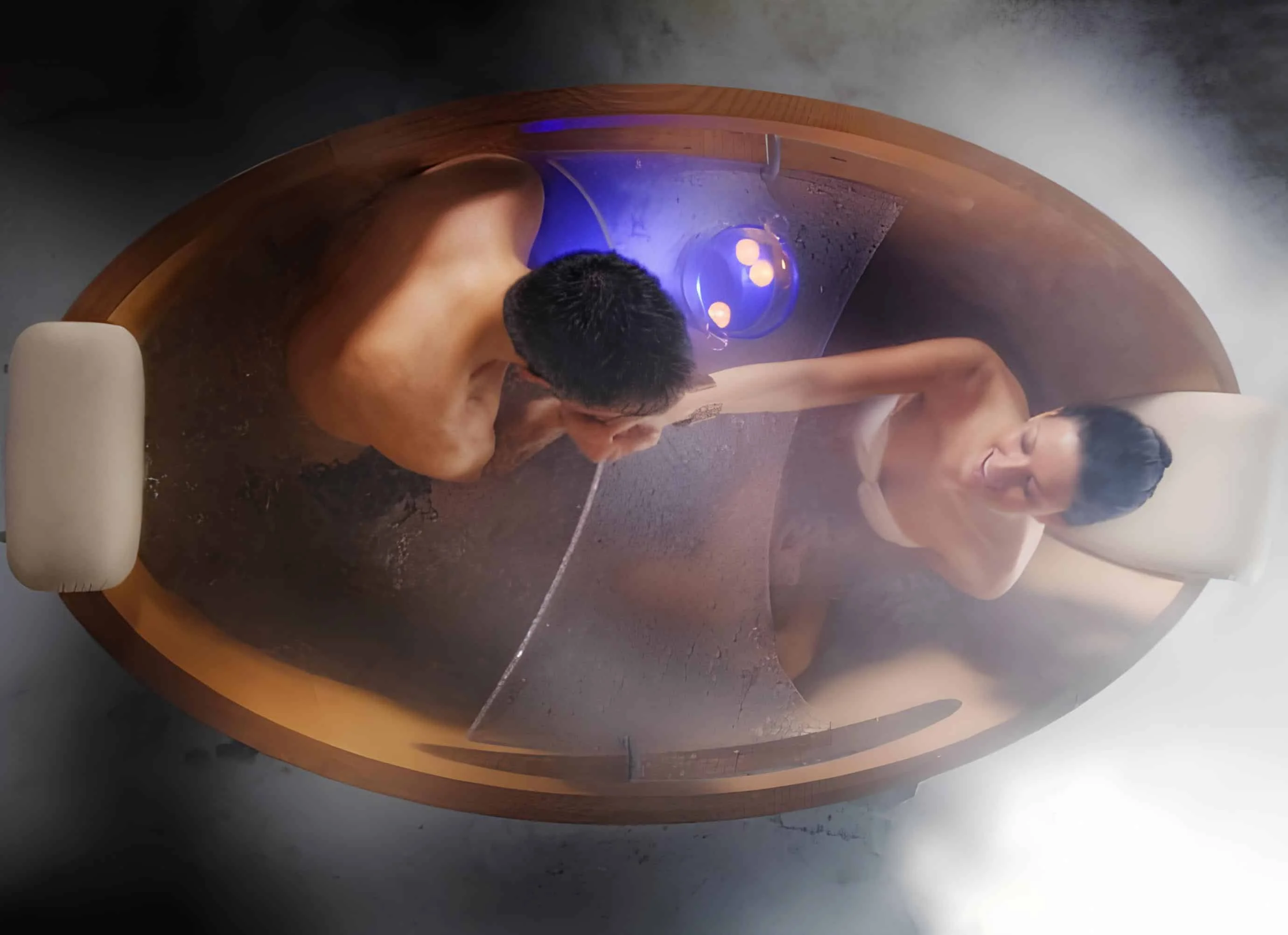 Romantic couple enjoying a steamy bath in a cozy wooden soaking tub