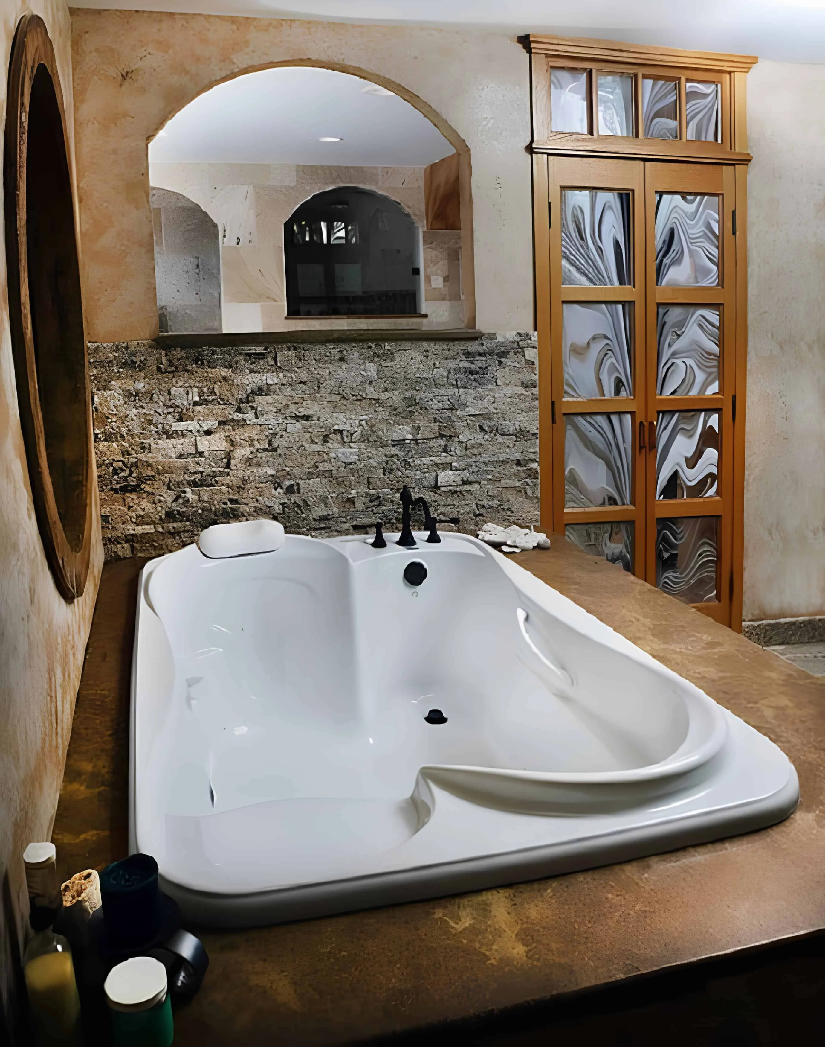 Rustic indoor bathroom with freestanding sculptural bathtub and arched mirror