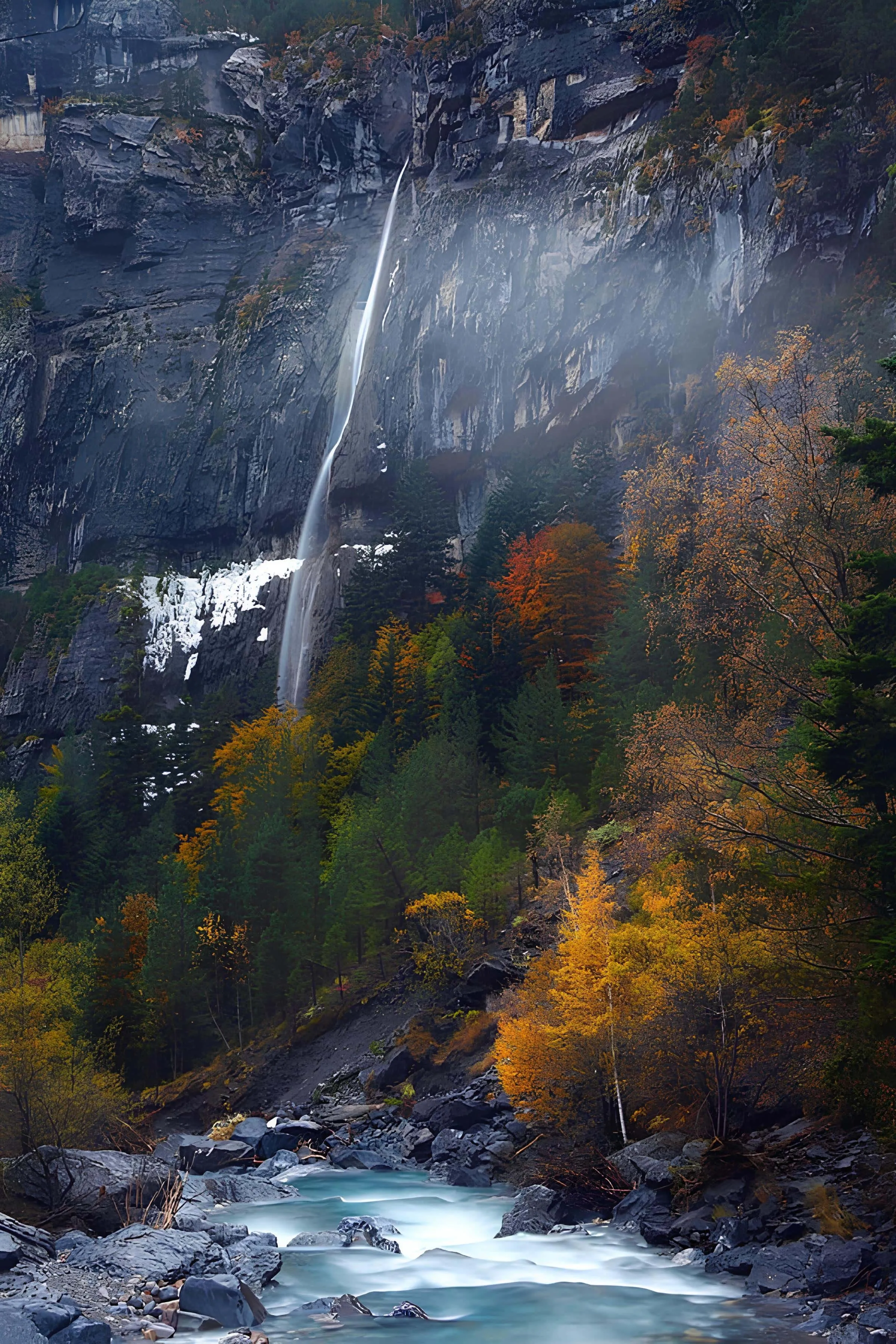Thin waterfall cascading down a cliff among vibrant autumn leaves