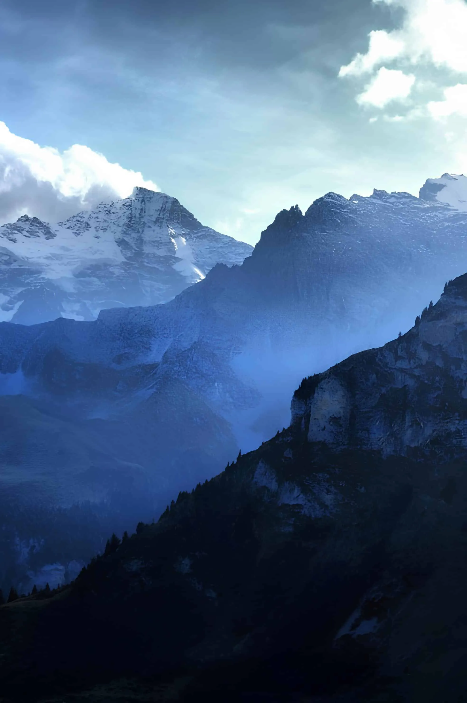 Layers of mountain ridges under a dramatic blue sky