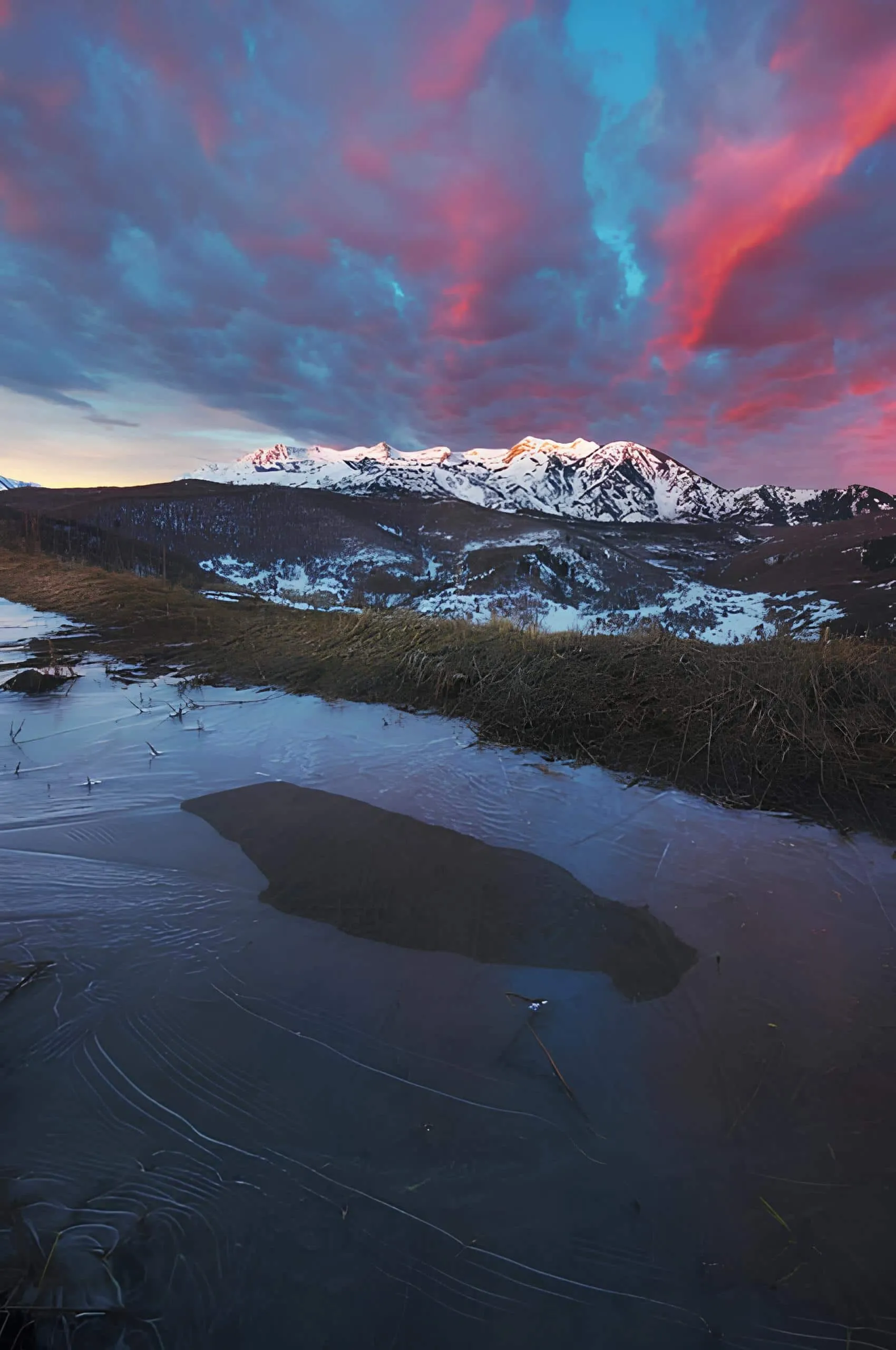Snow-capped mountains glowing under a dramatic dawn