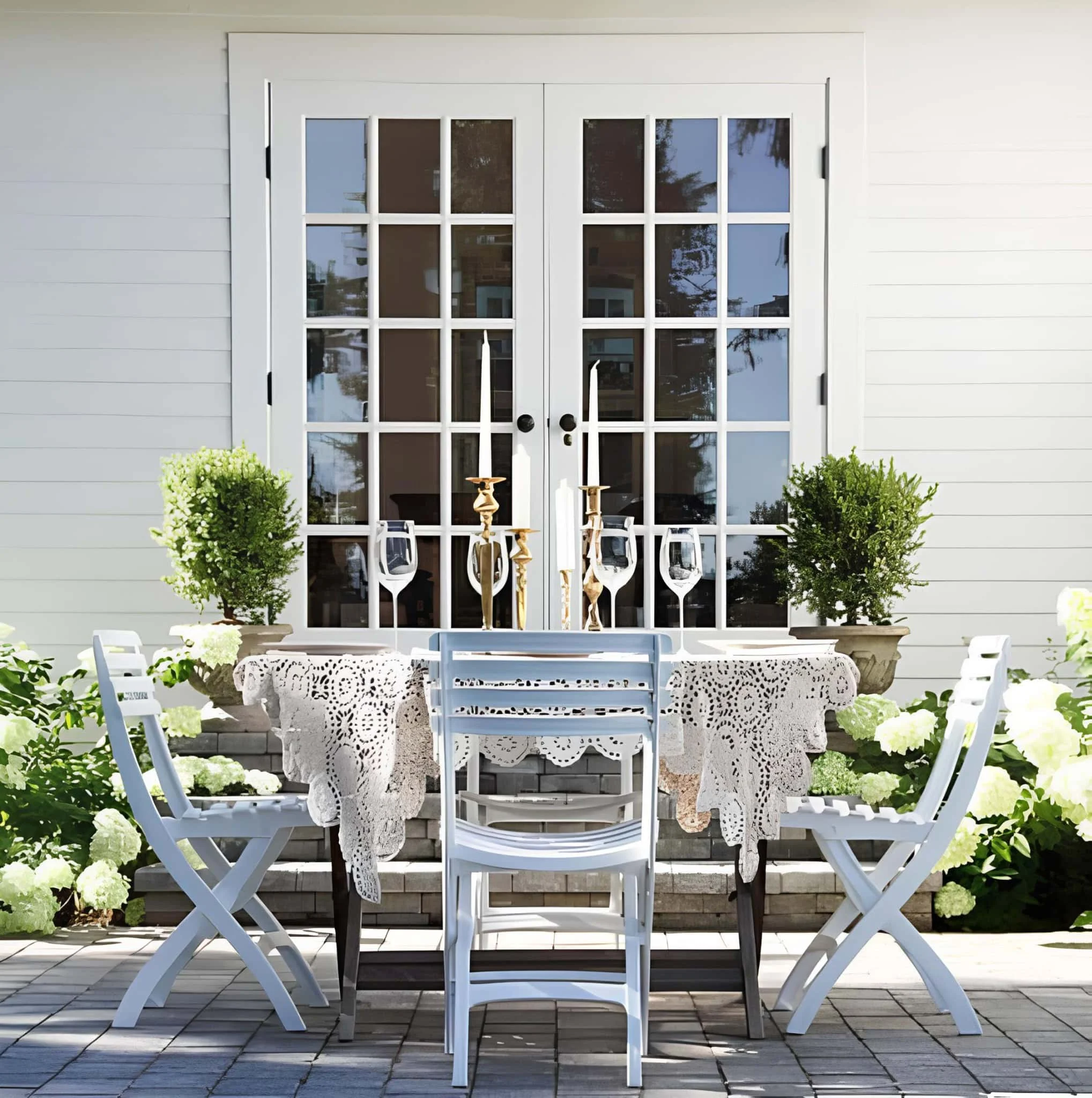 Mesa de comedor al aire libre con toalla de encaje y velas doradas