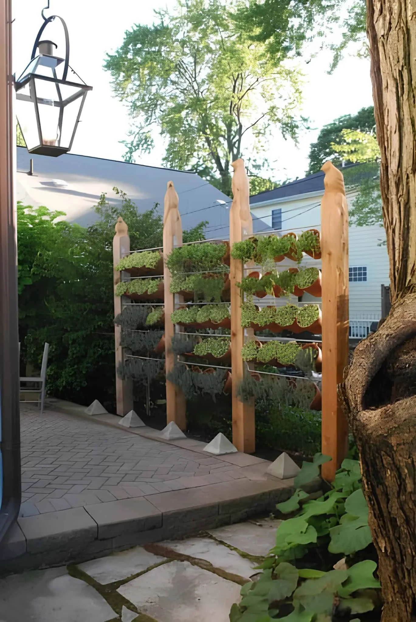 Vertical garden structure with carved wood posts and rows of herbs