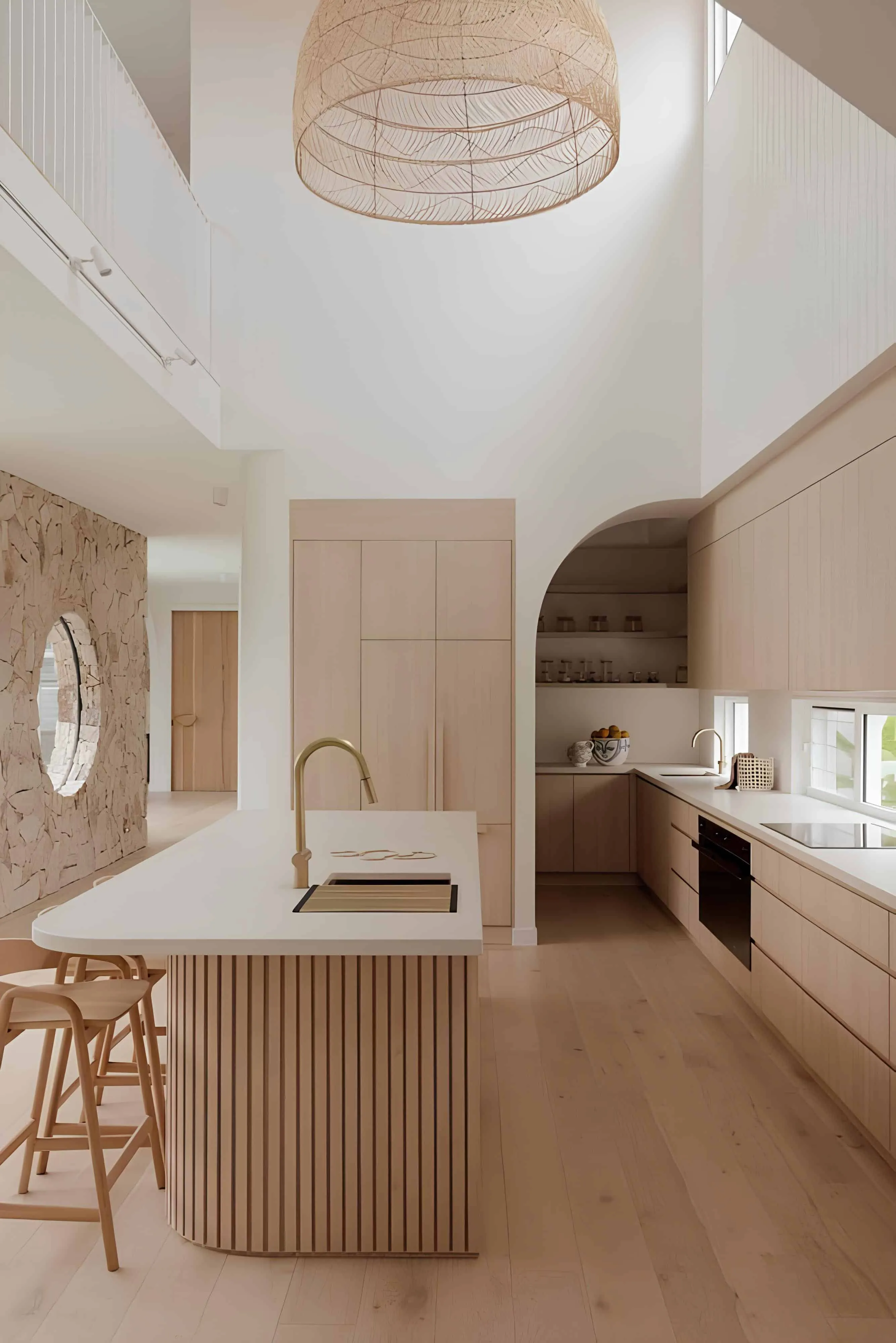 带拱形入口门的现代厨房 带拱形储藏室、岛台和木质门板的明亮开放式厨房