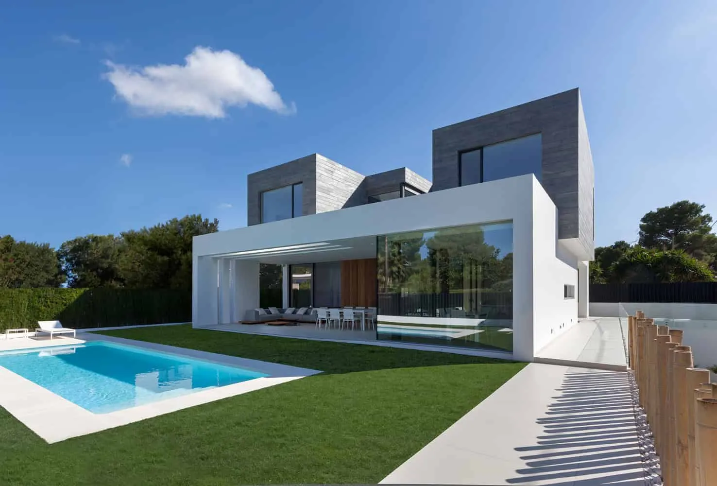 白色餐桌与邻近泳池的极简户外露台