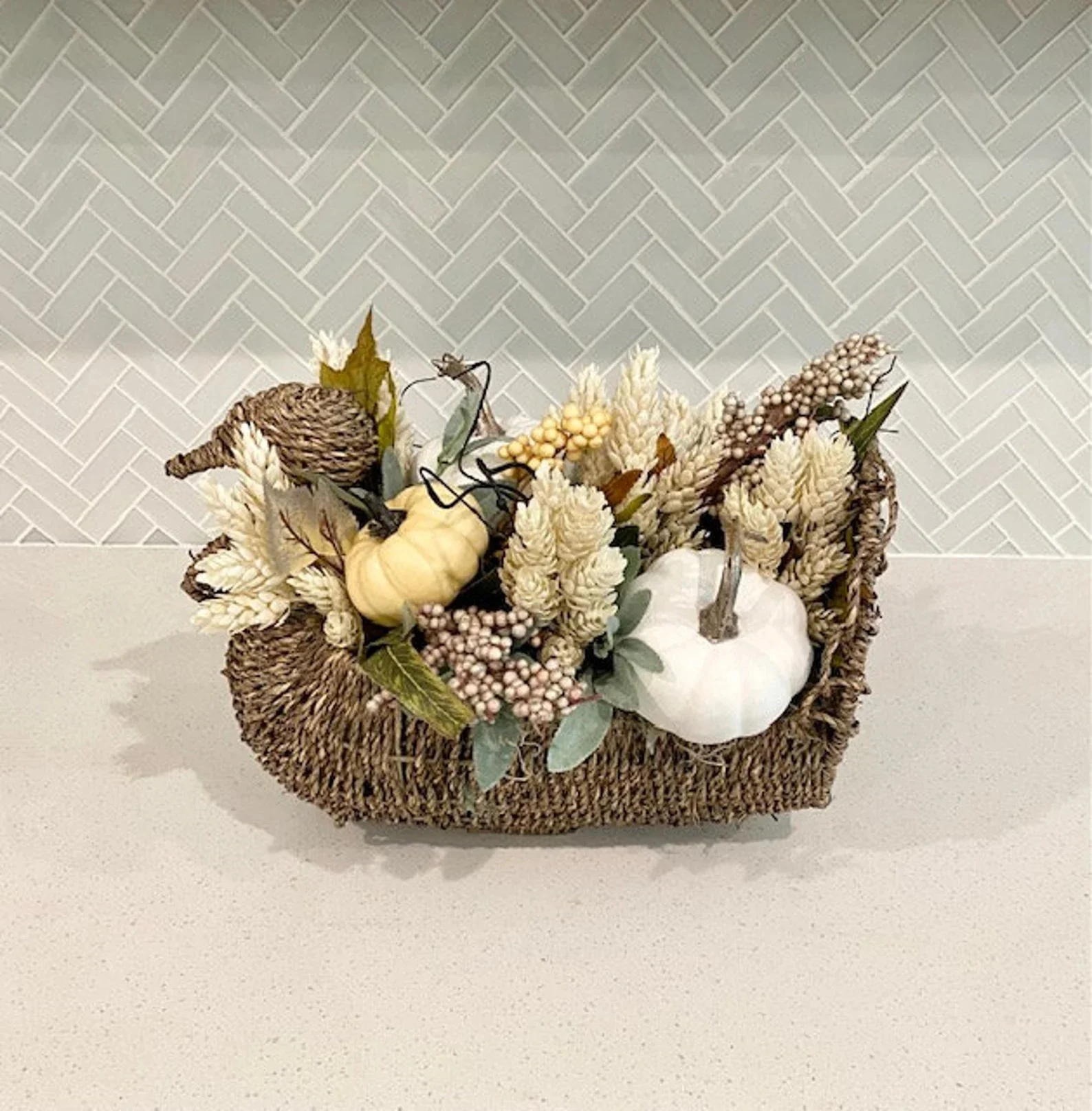 14. Calabazas, hojas, trigo y bayas en una cesta de madera trenzada