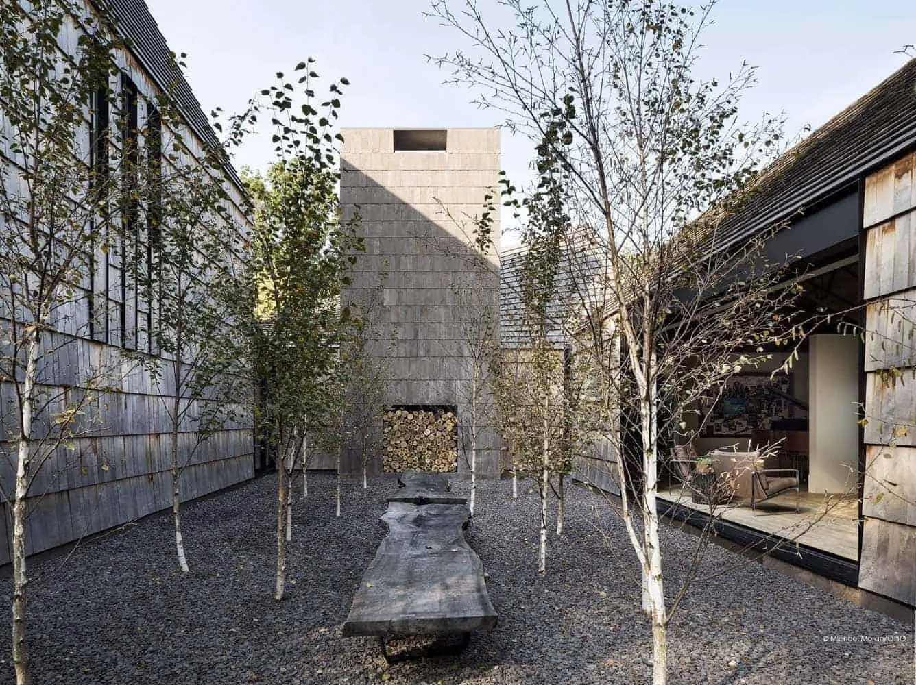 Inner courtyard with birch trees and central fireplace.