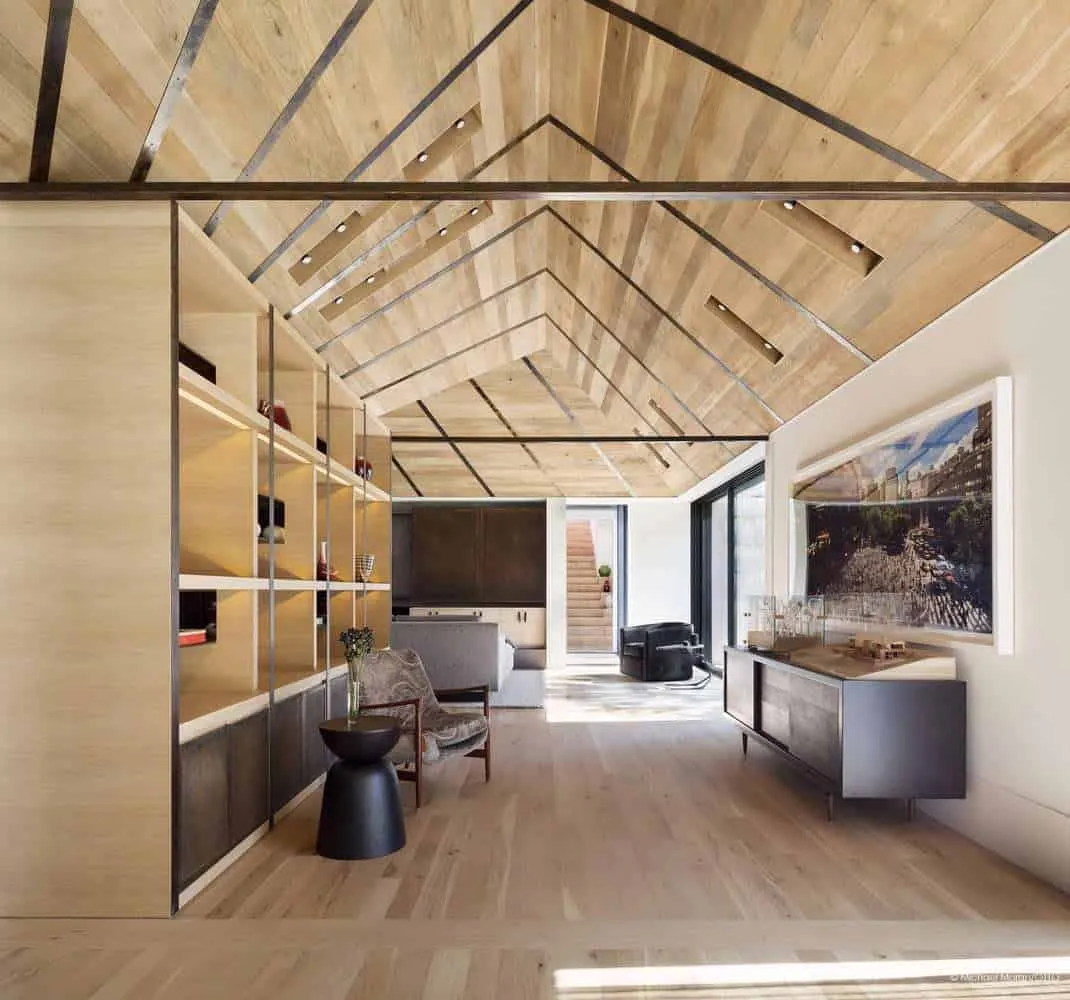 Living space with custom open shelving and arched wooden ceiling.