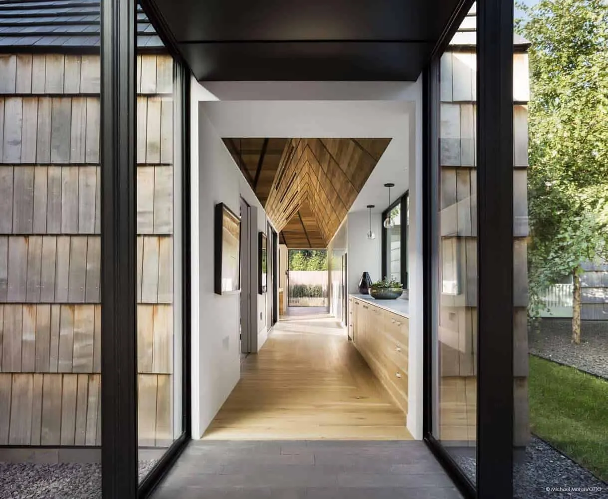 Modern kitchen corridor with wooden ceiling and natural light.