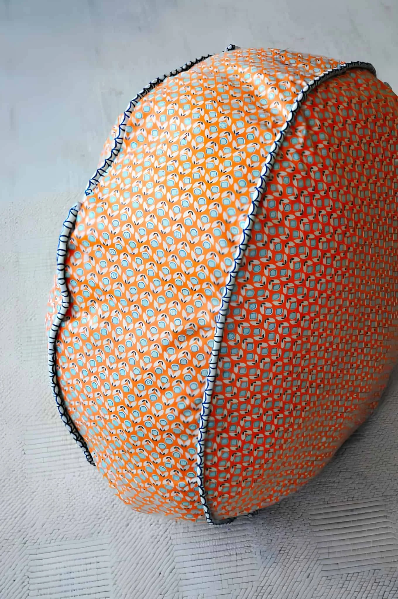 Telas estampadas brillantes usadas para crear un puf redondo hecho a mano