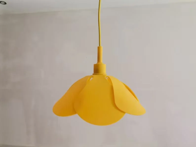 8. Lámpara de plástico amarilla con colgante floral