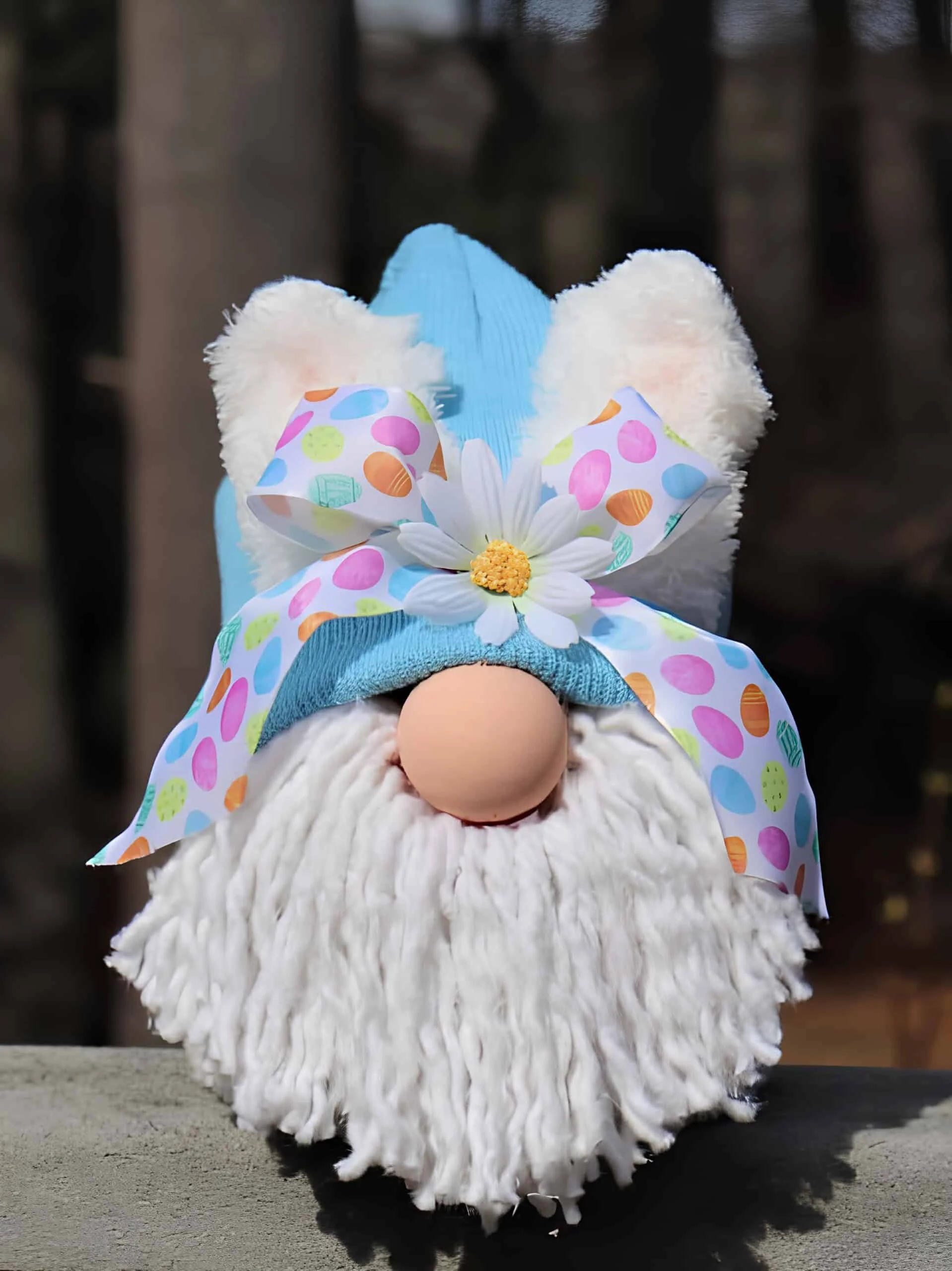 DIY gnomo de Easter con sombrero azul, orejas blancas espesas del conejo, barba falsa de piel, nariz rosa y cinta con huevos estampados, decorado con diente de león blanco - decoración primaveral imaginativa de Dollar Tree
