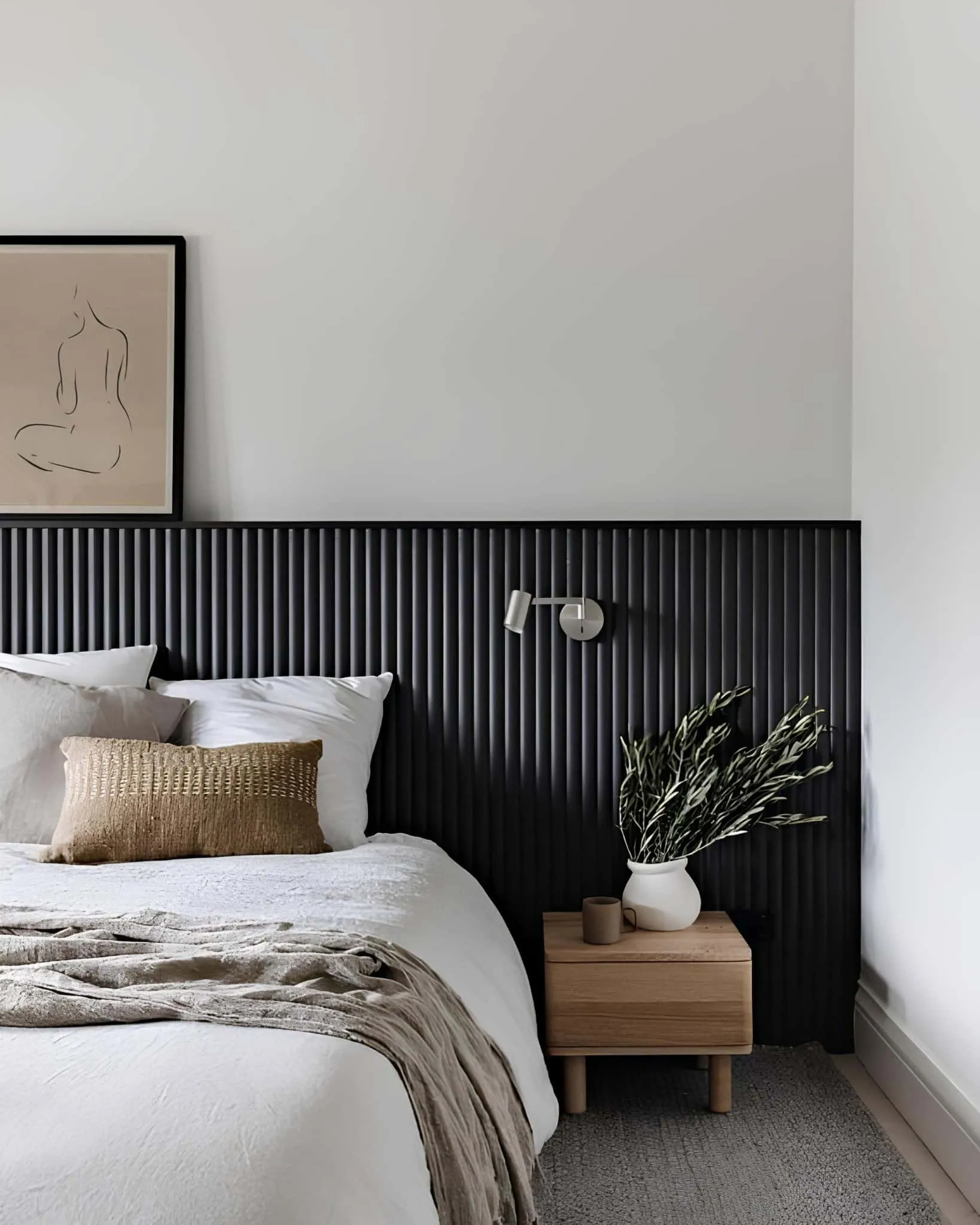 极简卧室配有黑色竖条床头板，柔软织物和简洁现代线条。