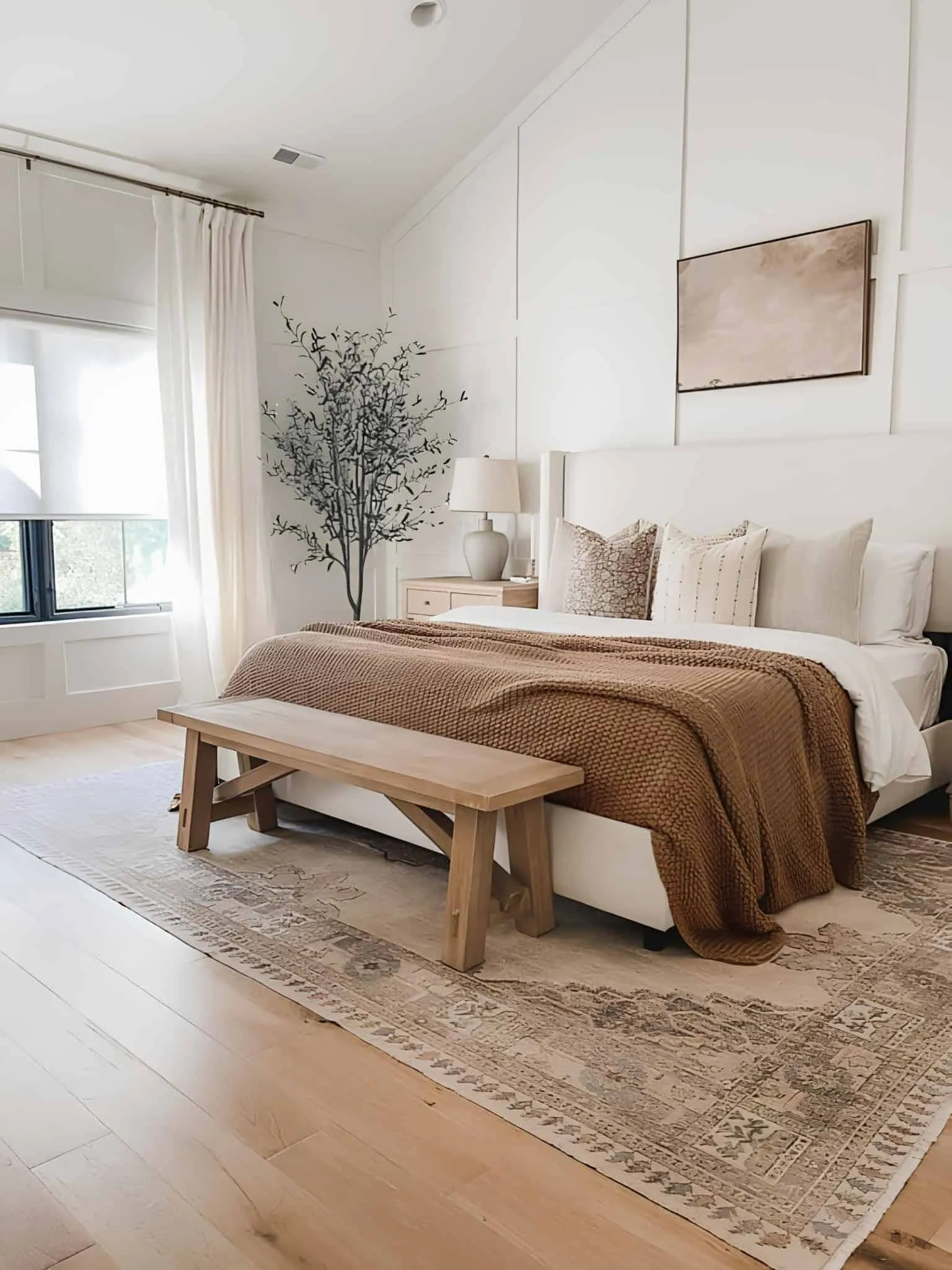 温暖舒适的卧室，具有层次纹理、木质床头柜和柔和中性色调。