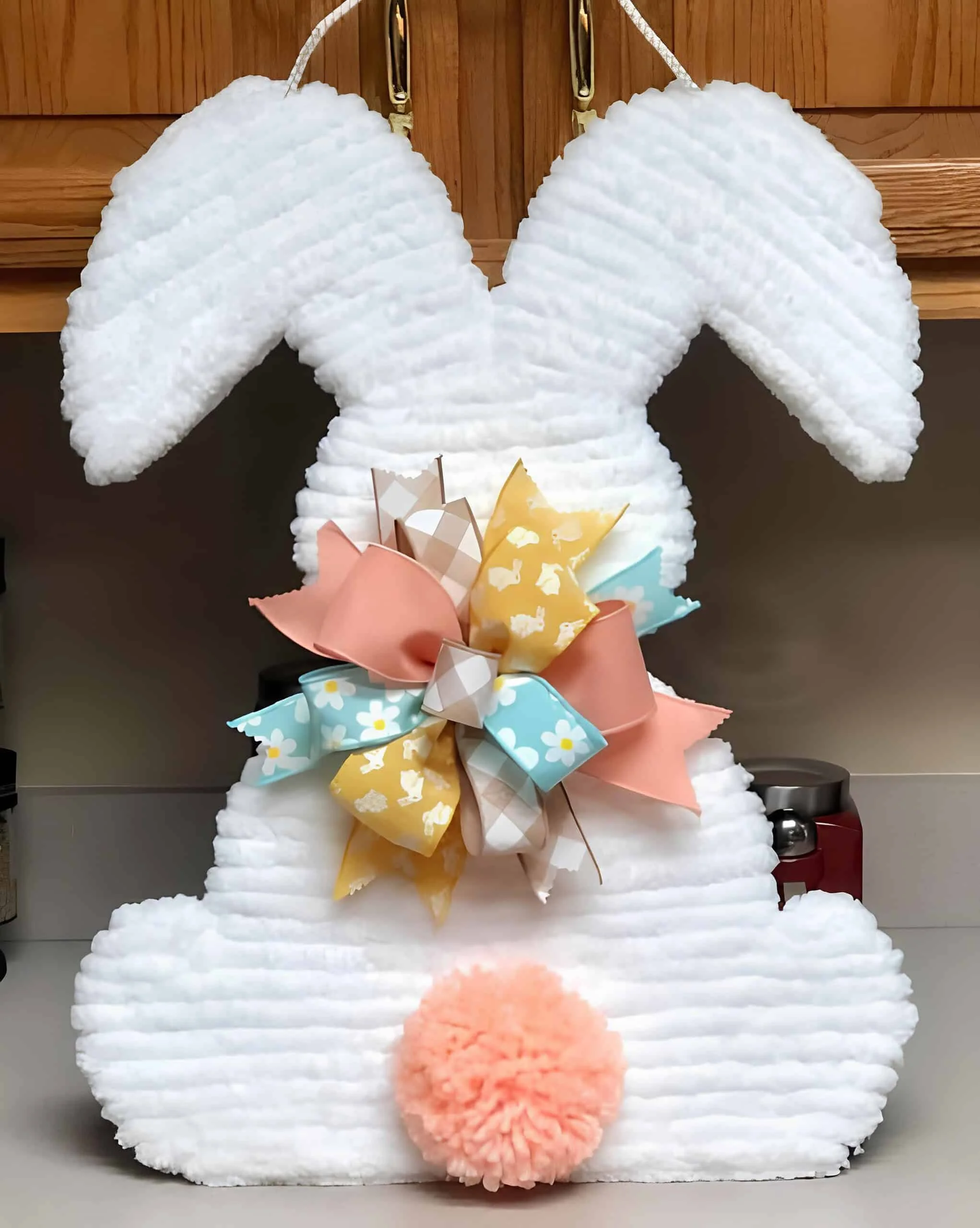 DIY guirnalda con el trasero de conejo hecho con tela chenille blanca, cinta floral y cola rosada espesa de peluche - manualidad adorable y creativa para Easter de Dollar Tree