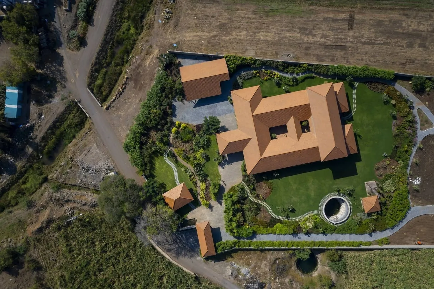 Terrace opening onto distant fields, framed by brick supports and a gabled roof overhang.