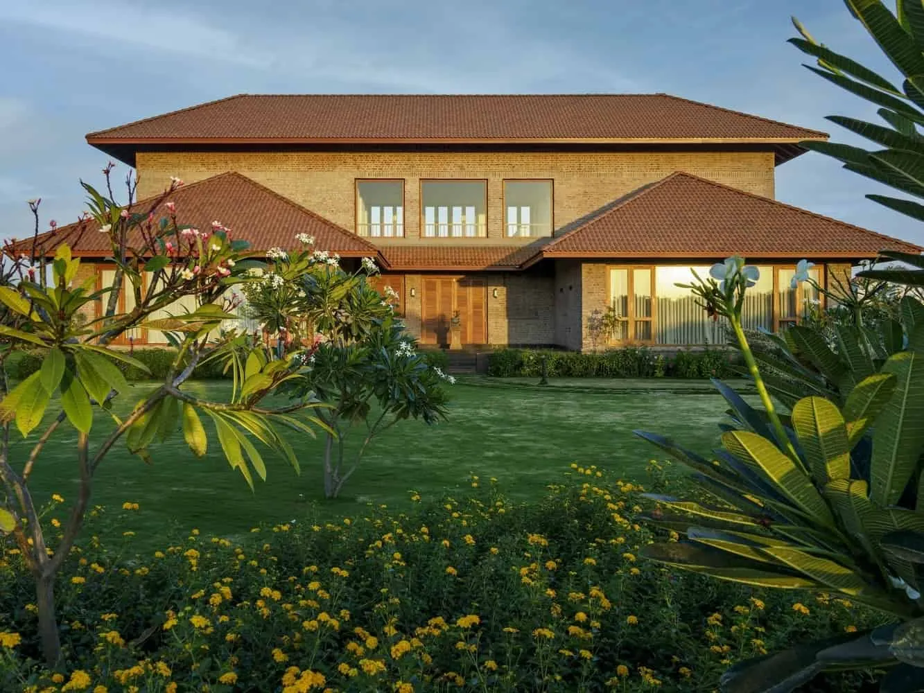 Deep overhangs shade a glass opening with plantings in the courtyard, channeling air inside.