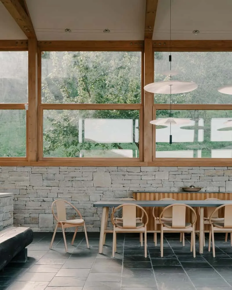 Low stone walls and soft planting material define intimate outdoor relaxation zones near the house.