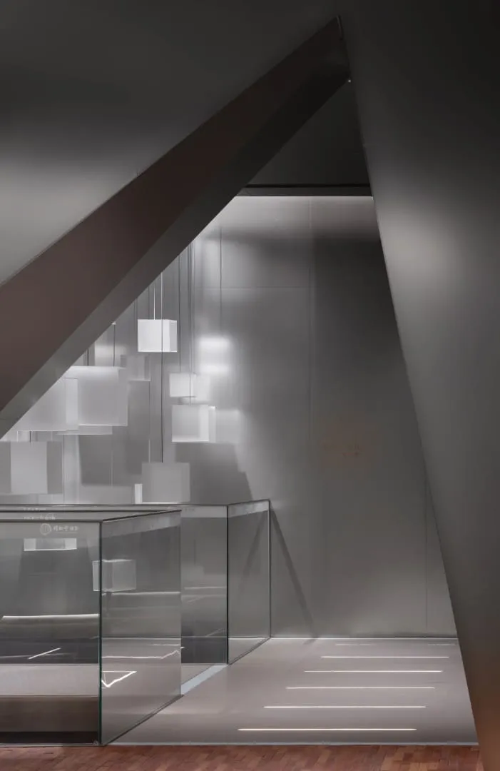 石材与镜面门槛，提供展陈章节间的触觉暂停