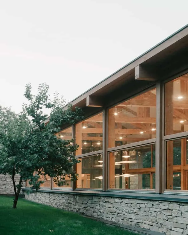 View from the living room where the landscape is read as part of the internal composition through large stained glass windows.