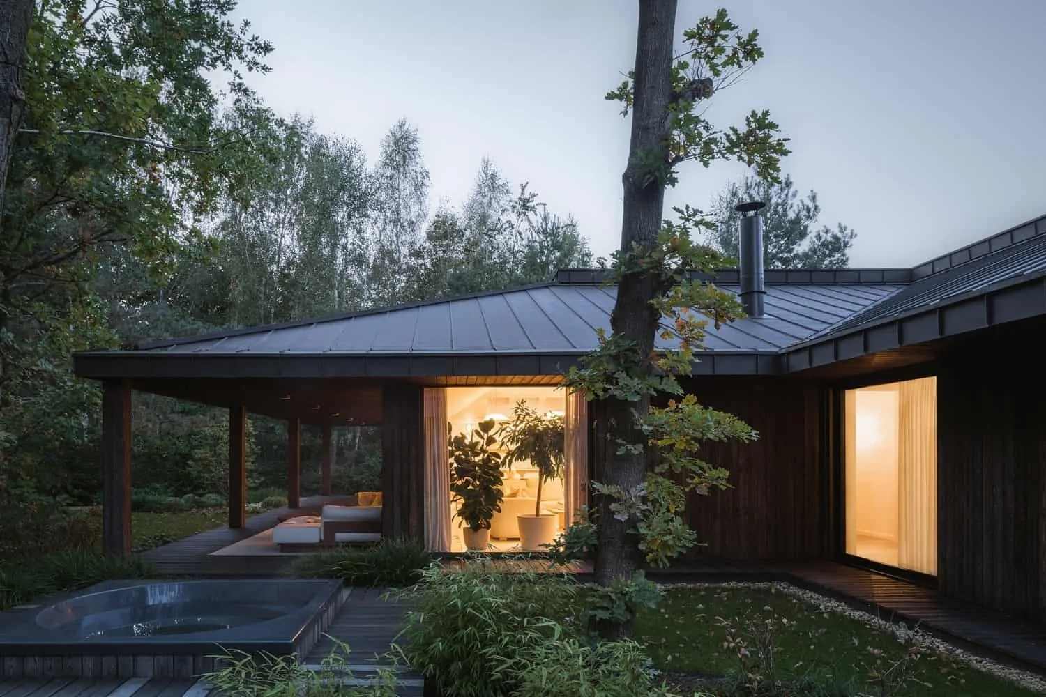 日落时分的外观，柔和内光照亮木柱和屋檐。