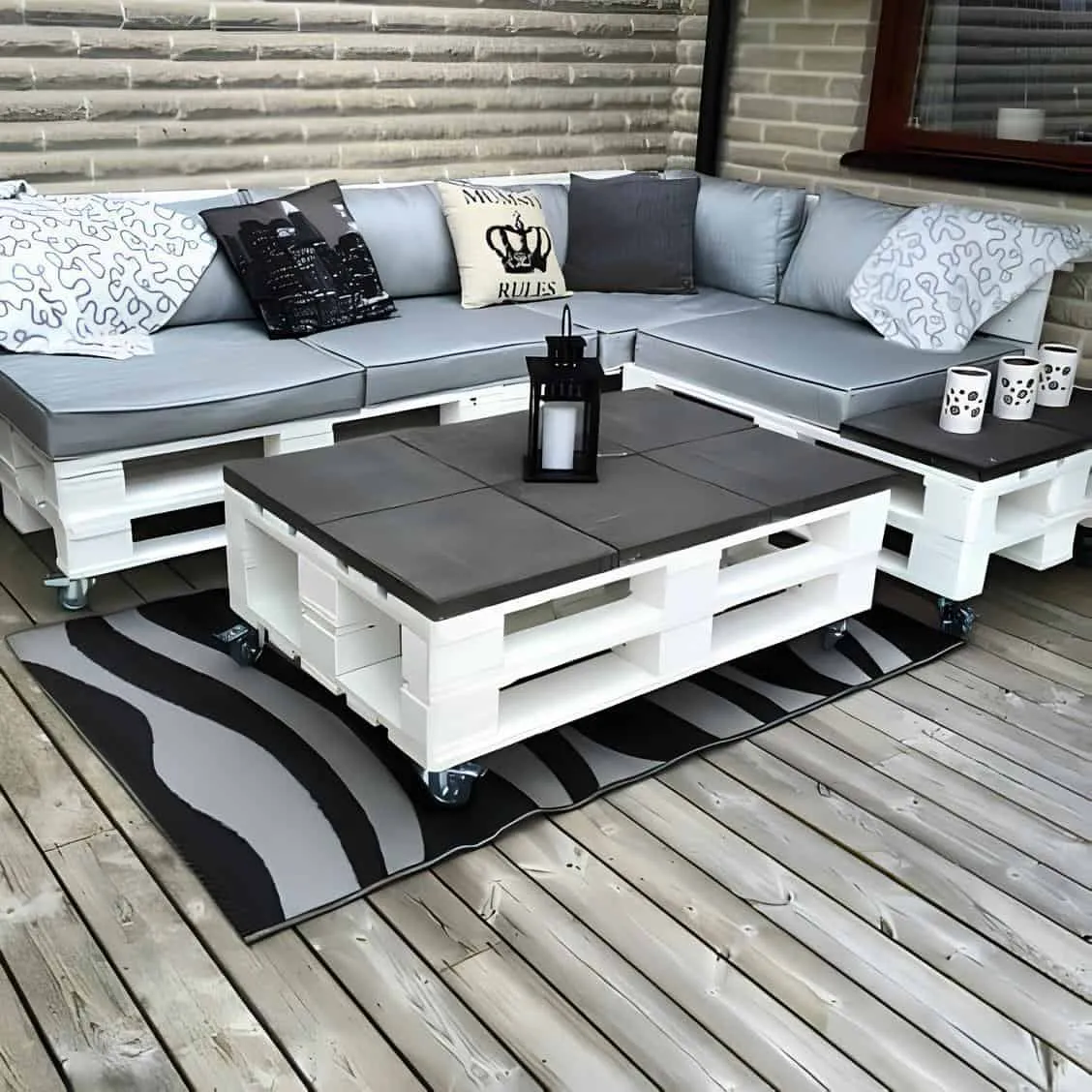 白色涂装的托盘制成的沙发和咖啡桌，配有灰色靠垫