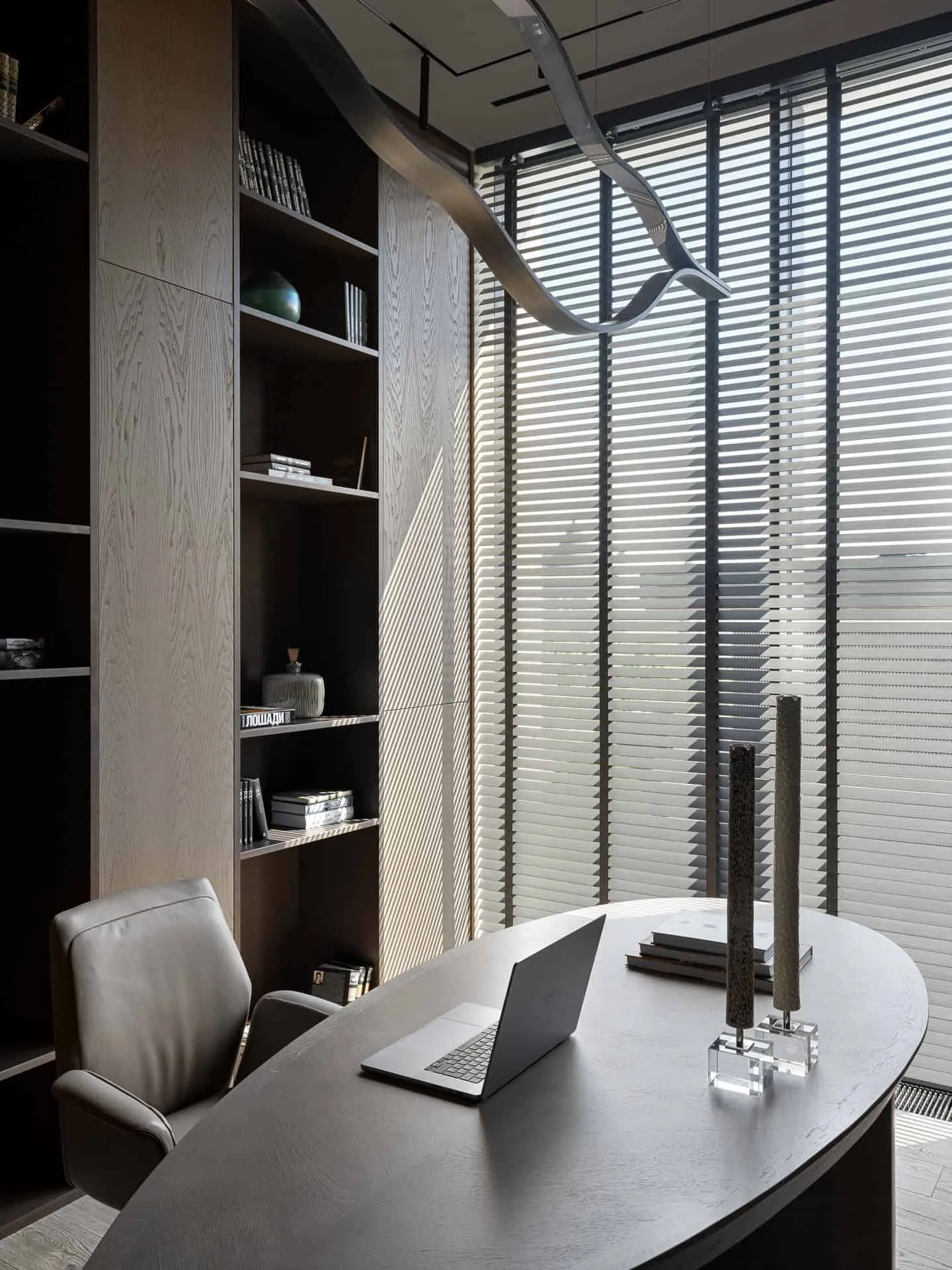 弯曲的主任办公室，面对高书架与大窗户。