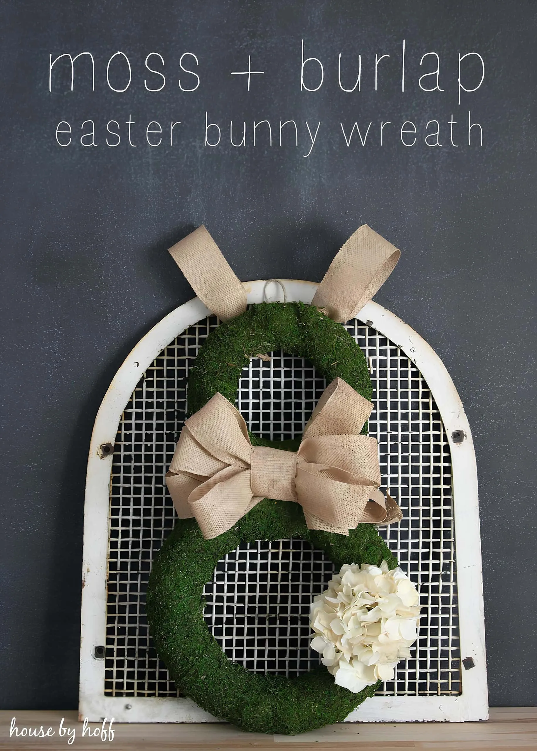 苔藓与粗麻布兔子门饰，配有耳朵和丝带，安装在旧框上。