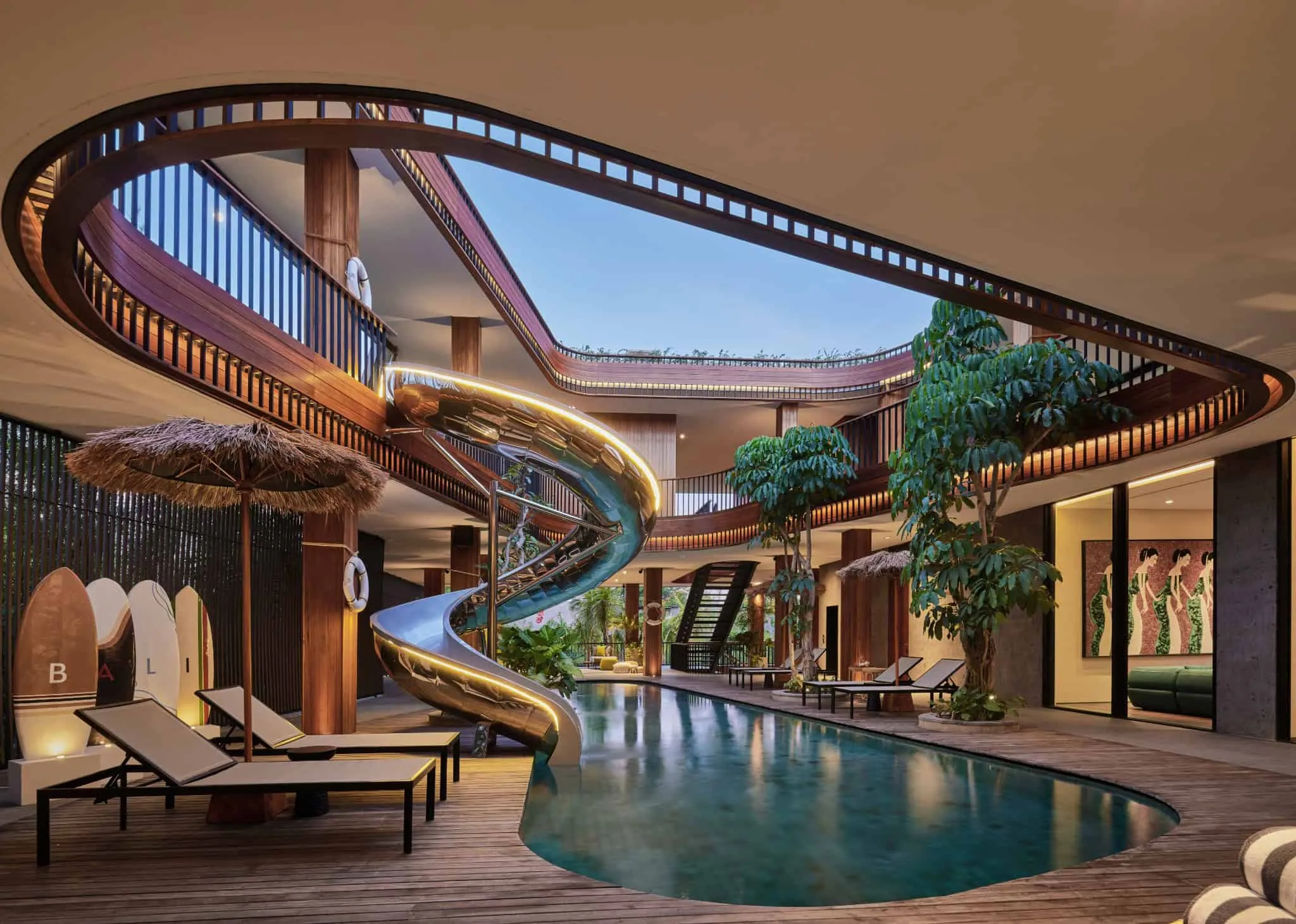 巴厘岛现代别墅，泳池发光，弯曲阳台在日落时分。