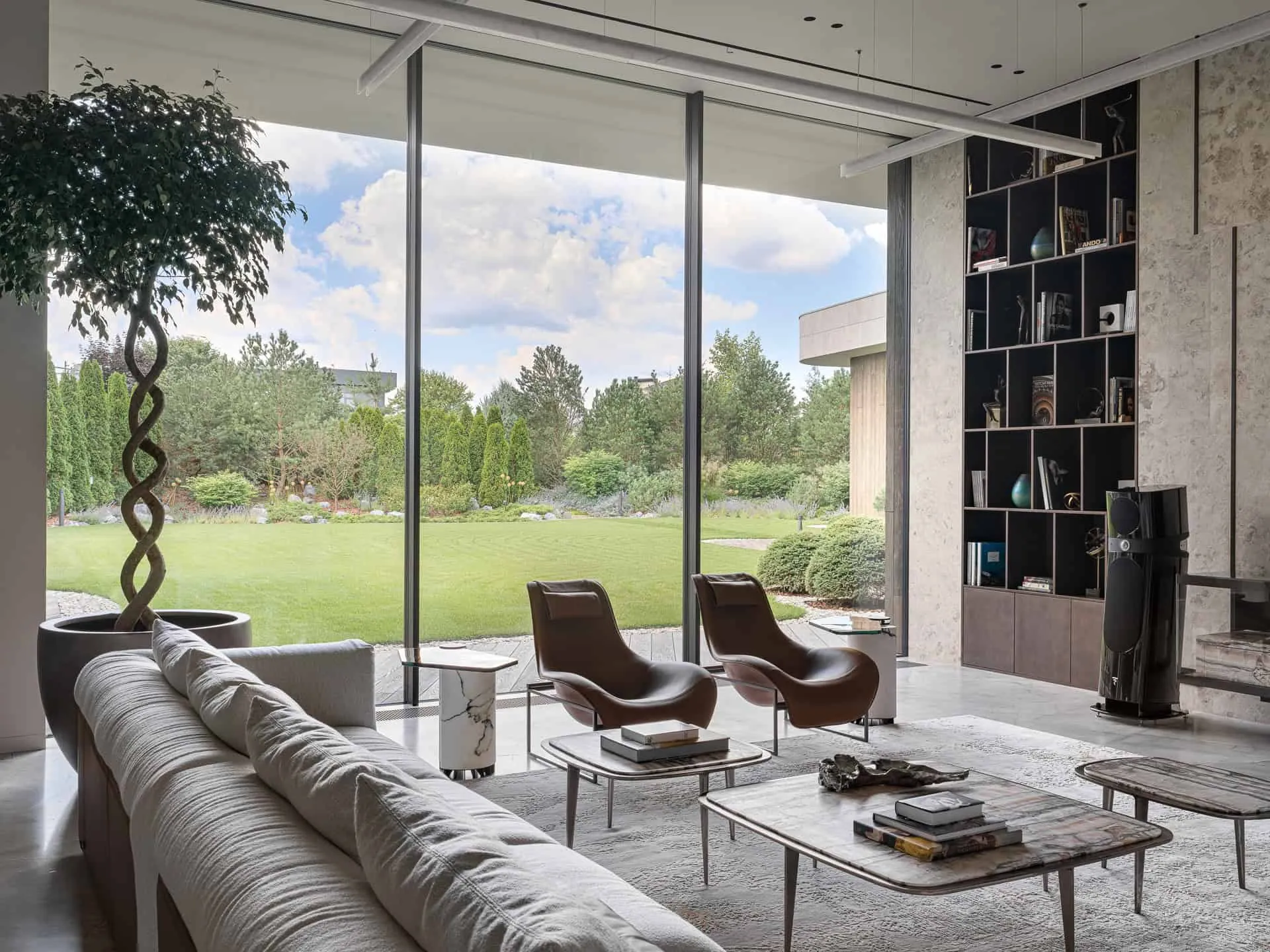 现代皮质扶手椅朝向玻璃窗，窗外是花园。