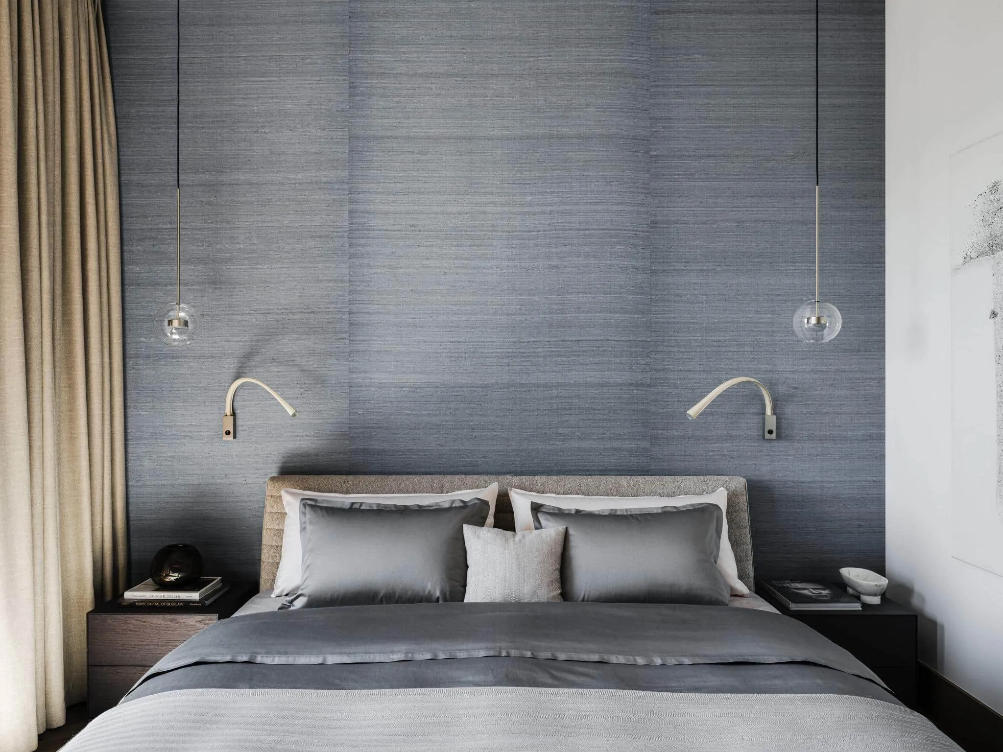 Gray bed with matching lamps and curtains.