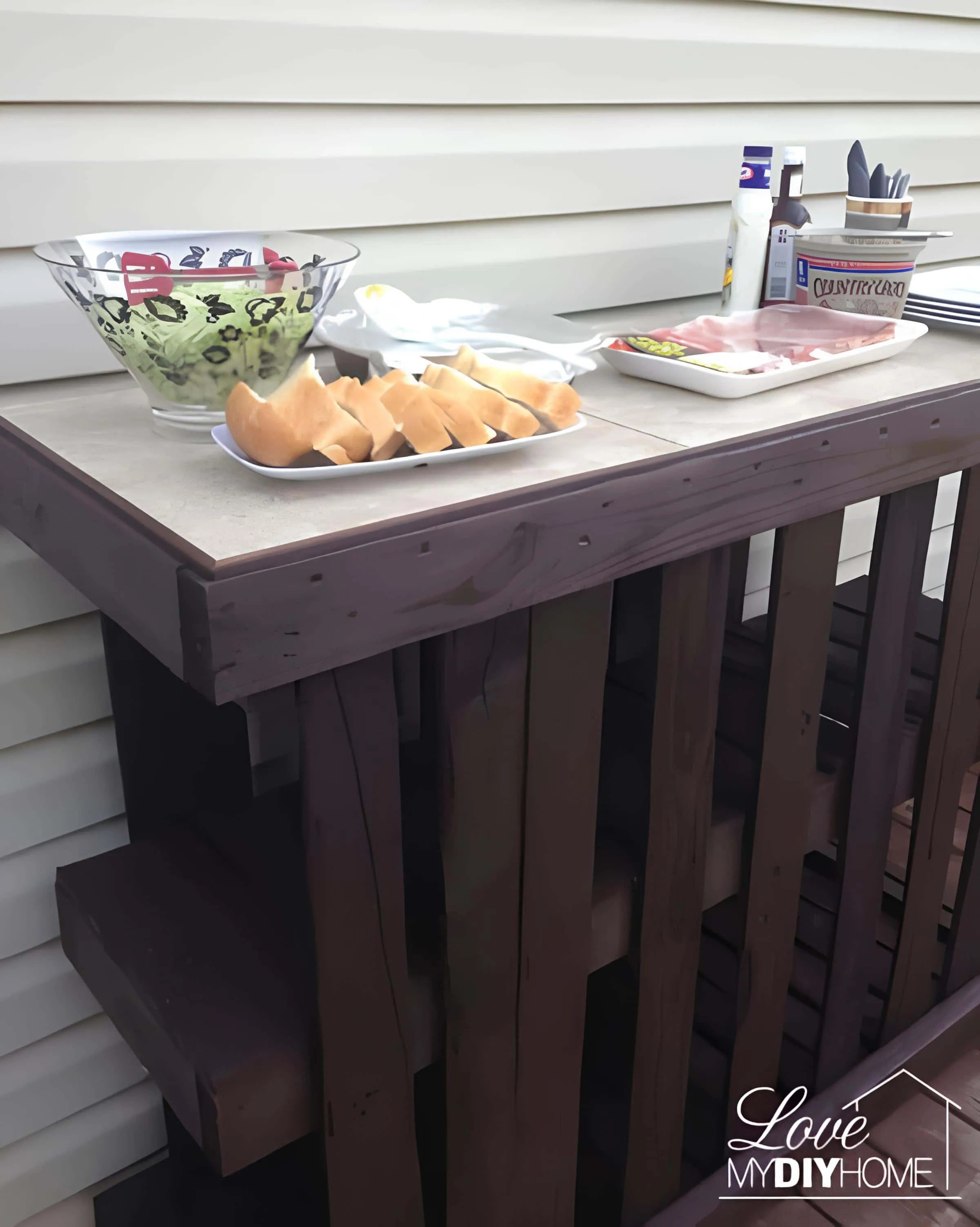 用托盘条制作的DIY酒吧台，配有小吃和饮料放在露台上