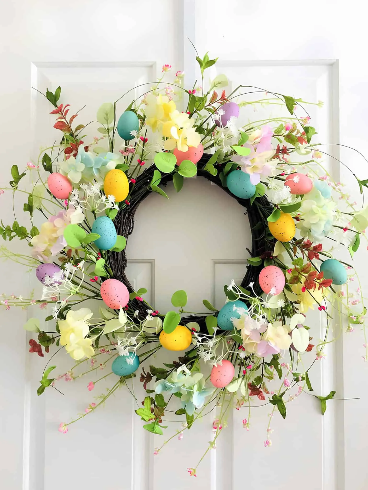 鲜艳的复活节门饰，配有假花和绿叶