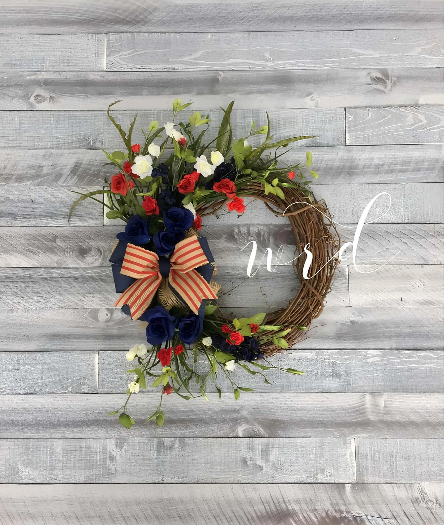 葡萄藤花环，配有红、白、蓝花朵和条纹丝带